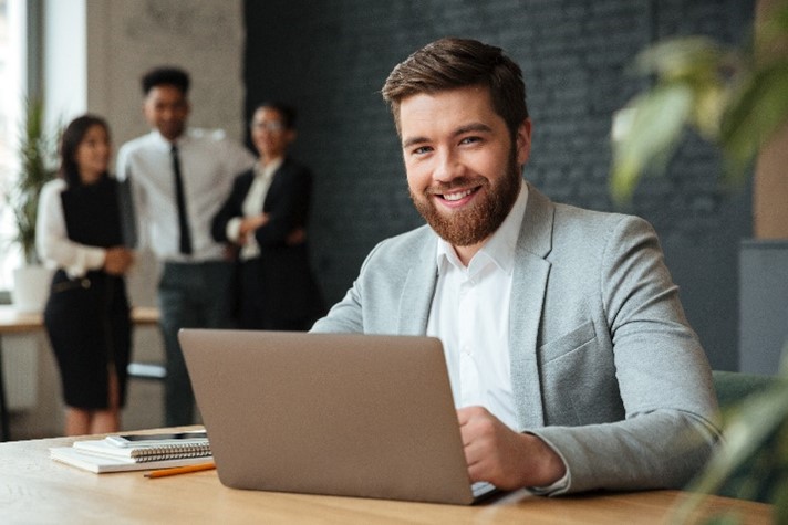 Homem sentado em frente a mesa com computador

Descrição gerada automaticamente